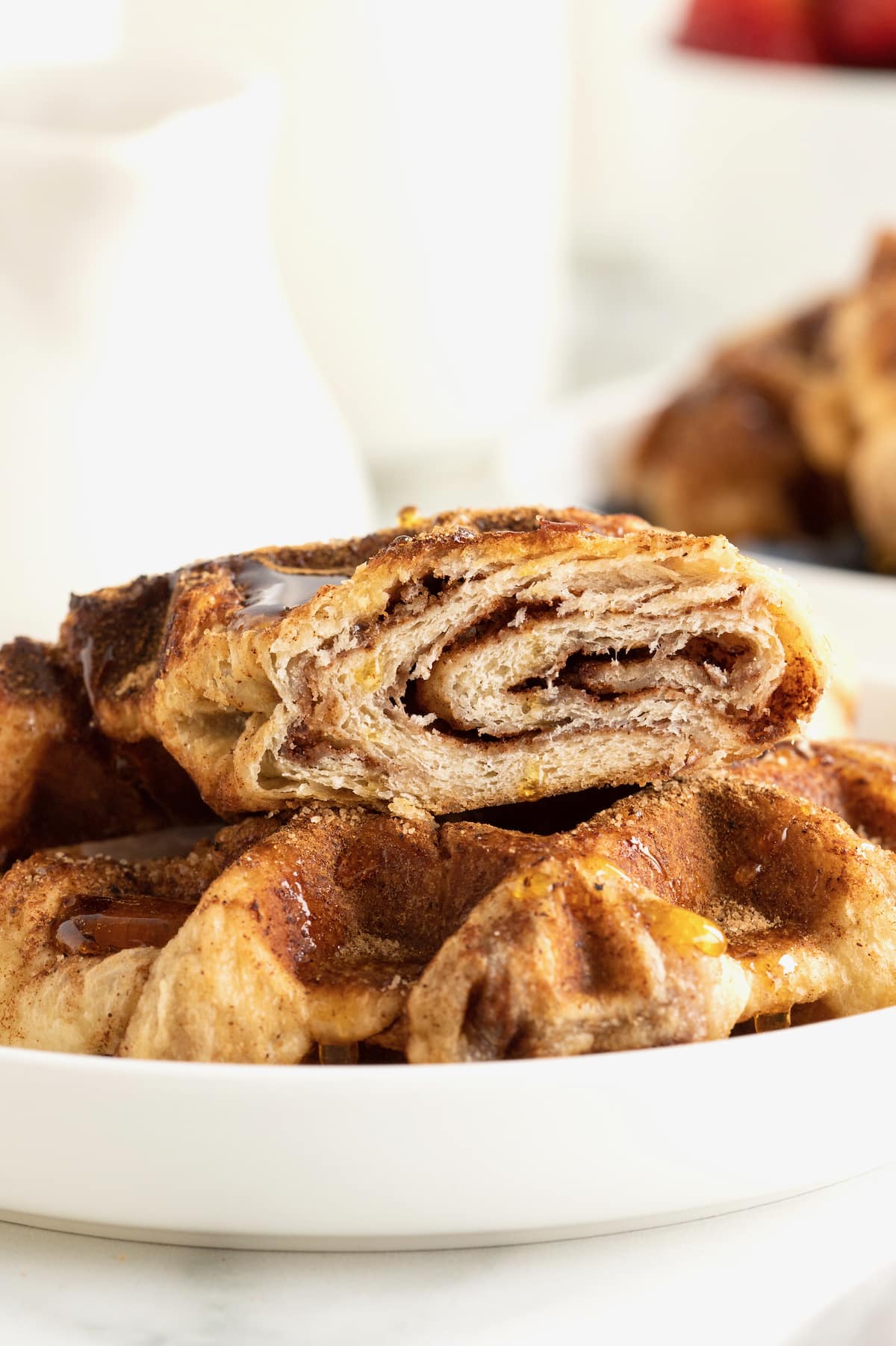 A cinnamon sugar Croffles cut in half to reveal layers of pastry and cinnamon sugar filling.