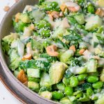 large bowl with cucumber, edamame, cashews, green onions and creamy miso dressing