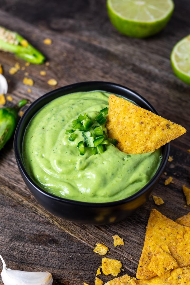tortilla chip dipped in creamy green sauce