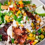 bowl with flaked chipotle salmon, mango pico de gallo, brown rice, shredded lettuce and creamy chipotle sauce