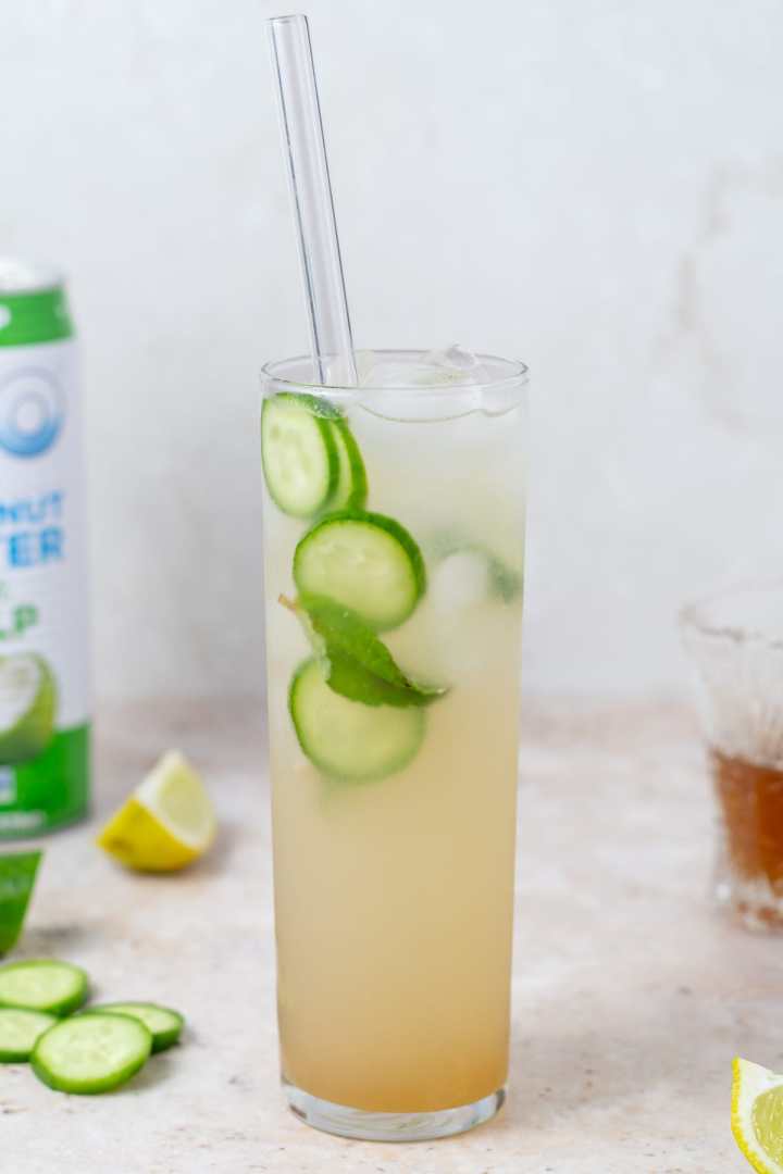 tall skinny glass filled with ice, coconut water, lime juice and mint honey syrup